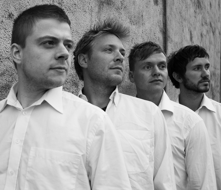 Byens Hotel — de fire medlemmer op ad en mur